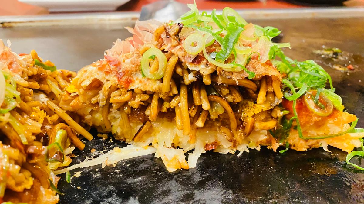お好み焼きの上にオムソバドーン