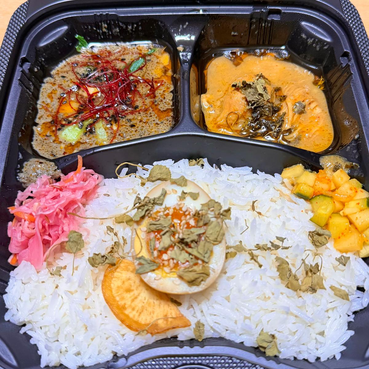 テイクアウト時の、二種あいがけカレー。左が黒胡麻坦々キーマ、右がスパイスチキンカレー。
